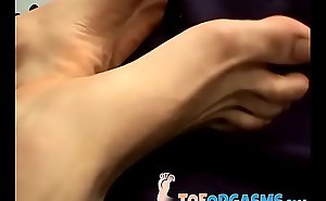 Handsome twink shows off his feet and strokes his big dick